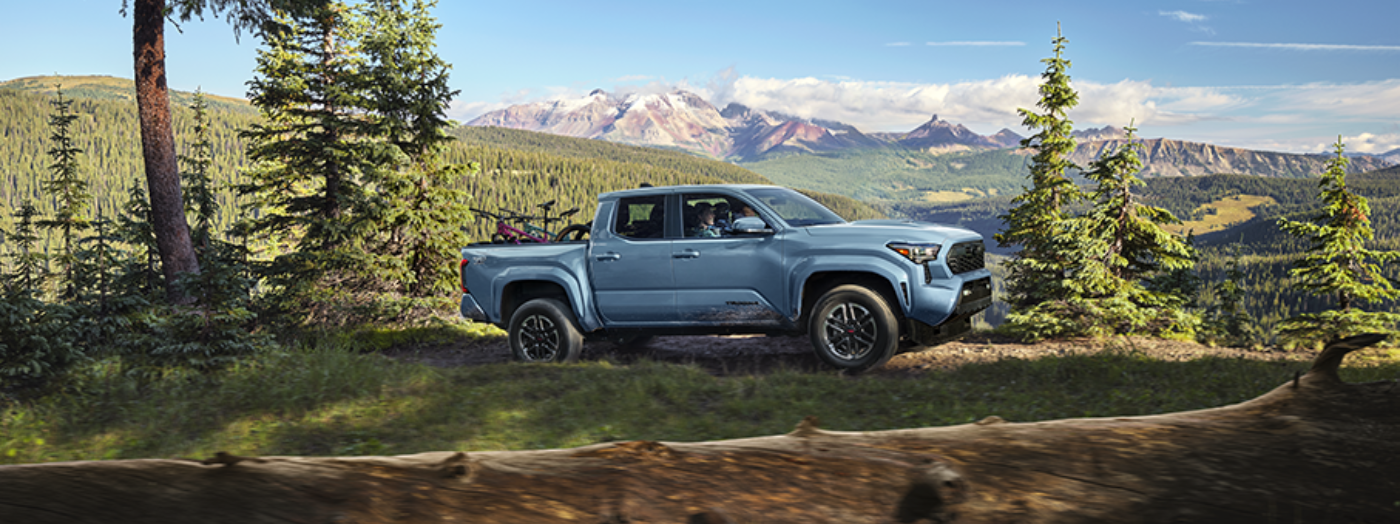Toyota Tacoma towing an ATV trailer through rugged terrain showcasing towing capability, off-road confidence, and adventure-ready performance