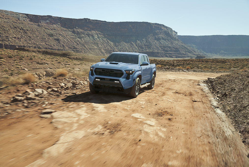 Toyota Tacoma TRD Sport driving through a mountain landscape highlighting midsize truck versatility, capability, and outdoor lifestyle appeal